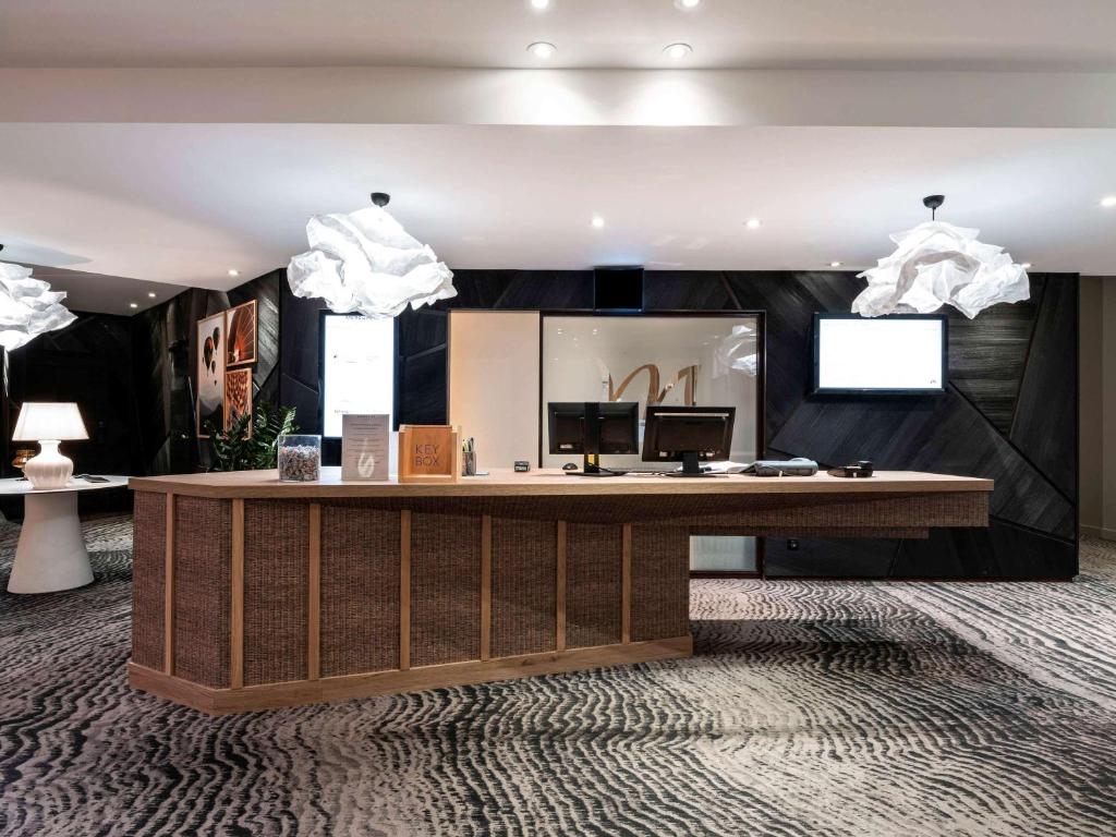 a lobby with a desk with a computer on it at Mercure Grenoble Meylan in Meylan