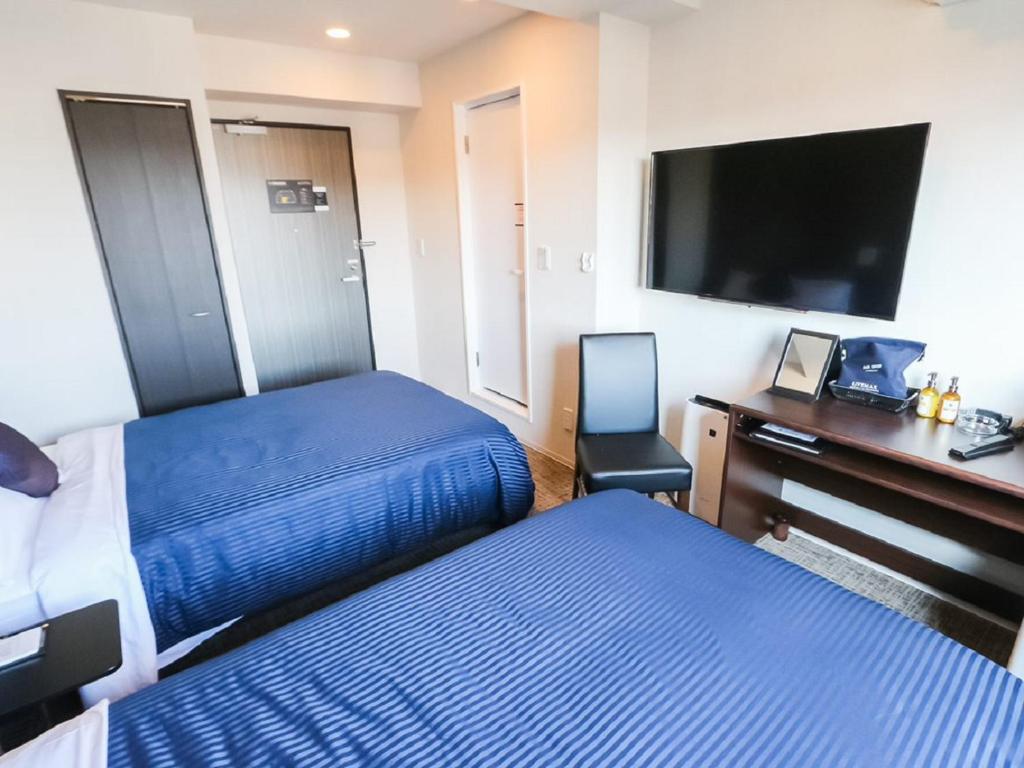 Postel nebo postele na pokoji v ubytování HOTEL LiVEMAX Hachioji Ekimae