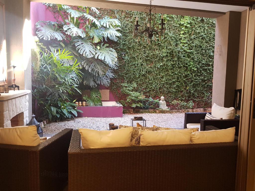 - un salon avec un canapé et un mur vert dans l'établissement InspireBA - Garden, à Buenos Aires