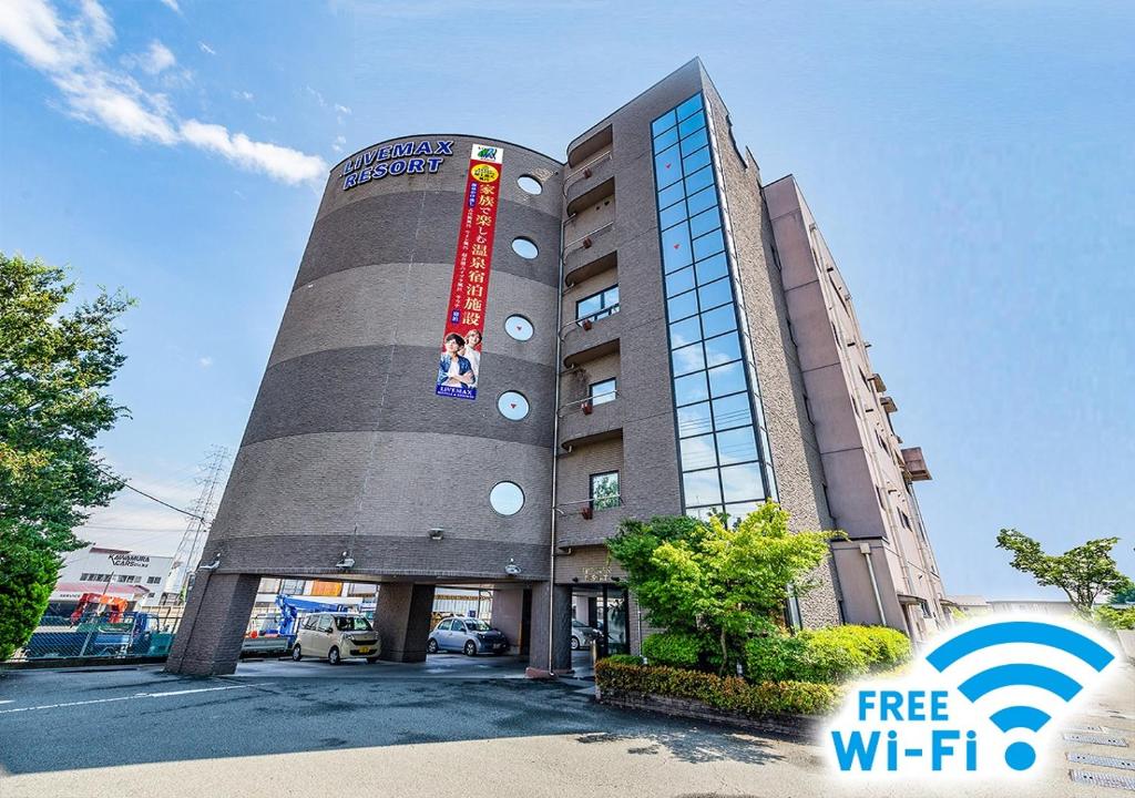 a building with a sign on the side of it at HOTEL LiVEMAX Kofu in Kai