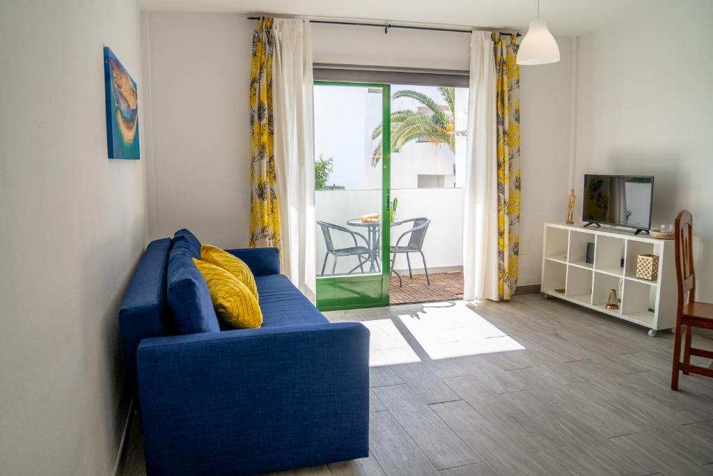 sala de estar con sofá azul y mesa en New & Renovated Vacation Apartment, en Costa de Antigua