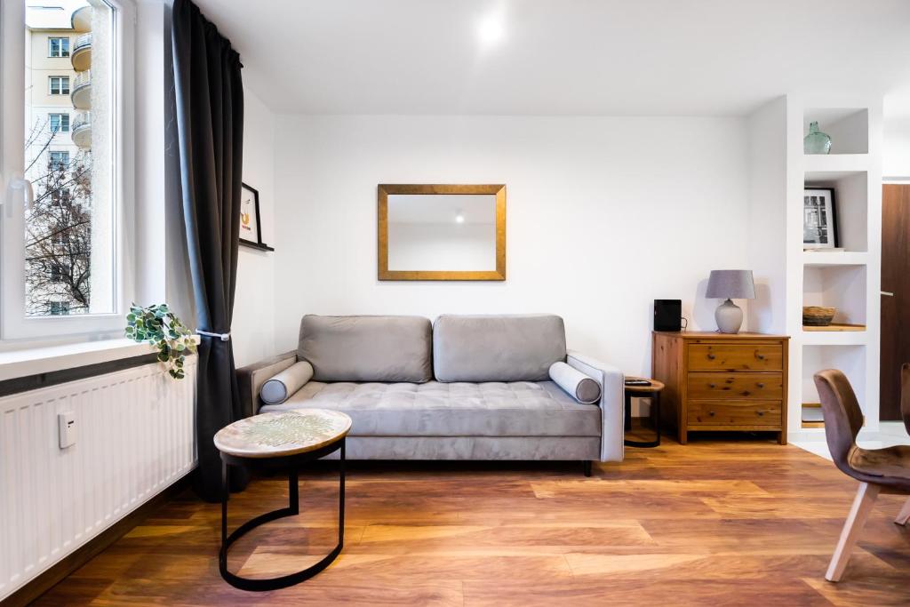 a living room with a couch and a window at Żoliborz Elite Apartment in Warsaw