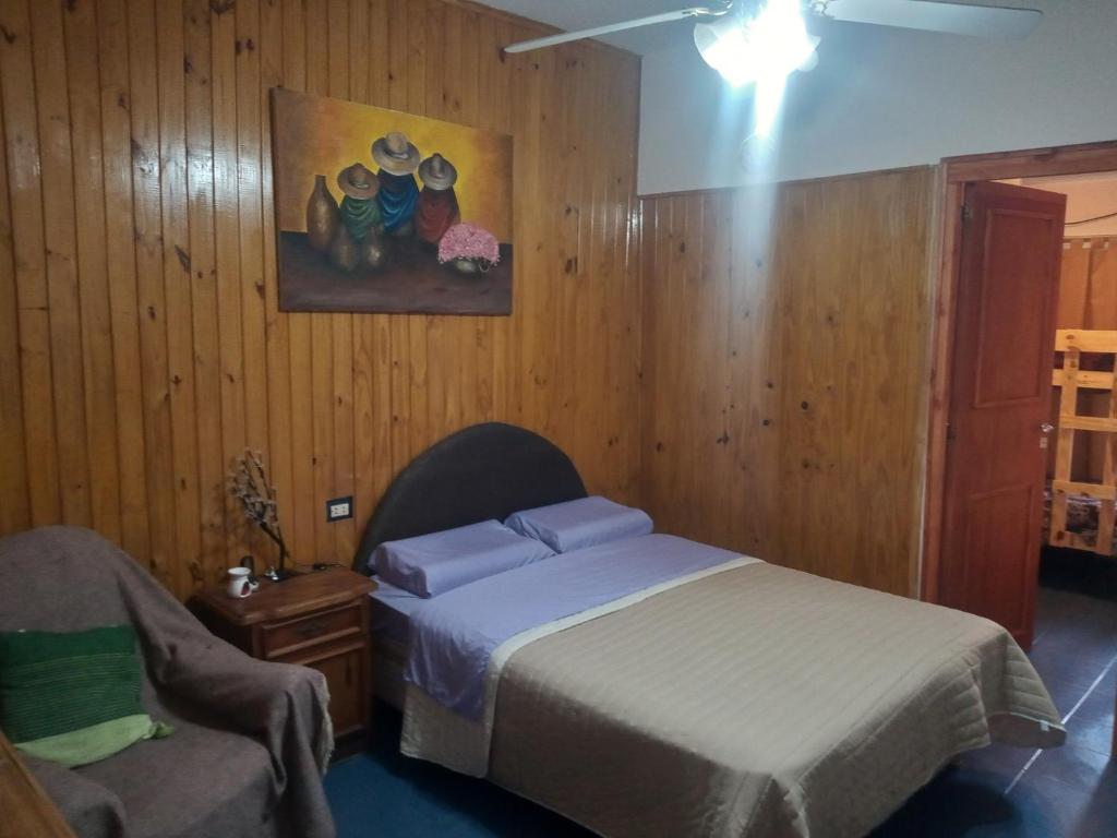 1 dormitorio con 1 cama y 1 silla en Estadía Don Roque en San Luis