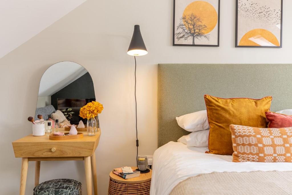 1 dormitorio con cama y mesa con espejo en Cohost Partners | Close to City Centre | One BR!, en Cardiff