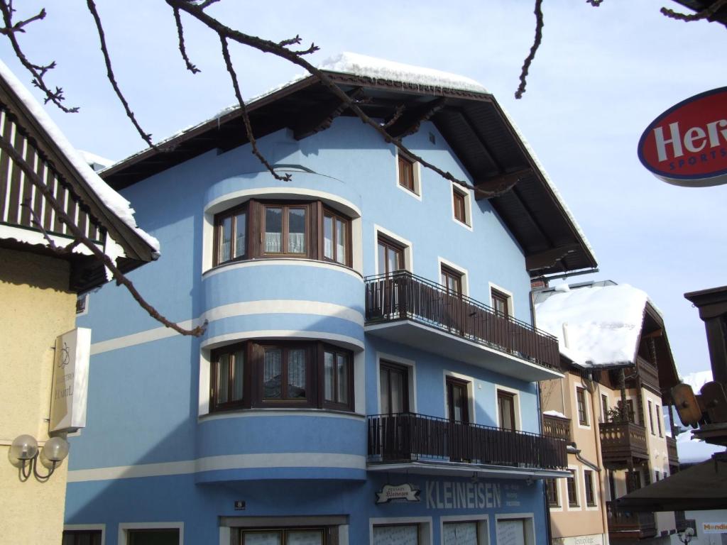 ein blaues Gebäude mit einem Balkon in der Unterkunft Haus Kleineisen by Châtel Reizen in Zell am See