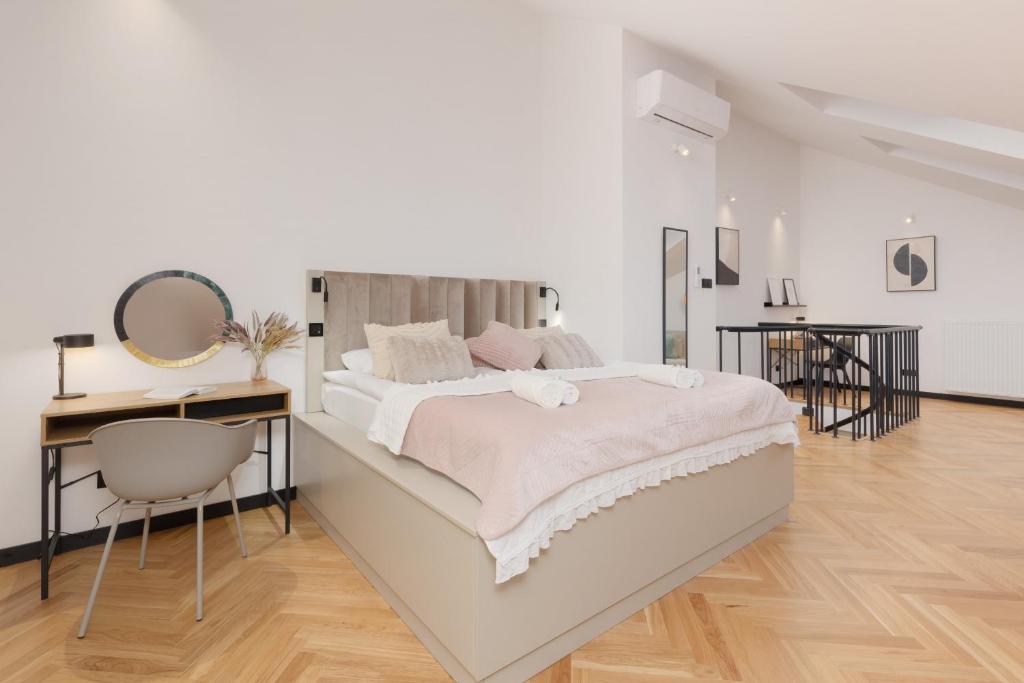 a white bedroom with a large bed and a desk at Praga Duplex Apartment Premium Warsaw by Renters in Warsaw