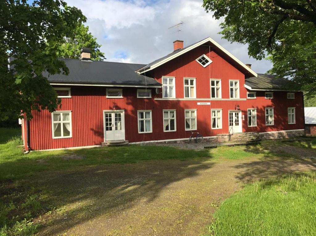 um celeiro vermelho com uma casa vermelha em Bruksgården 