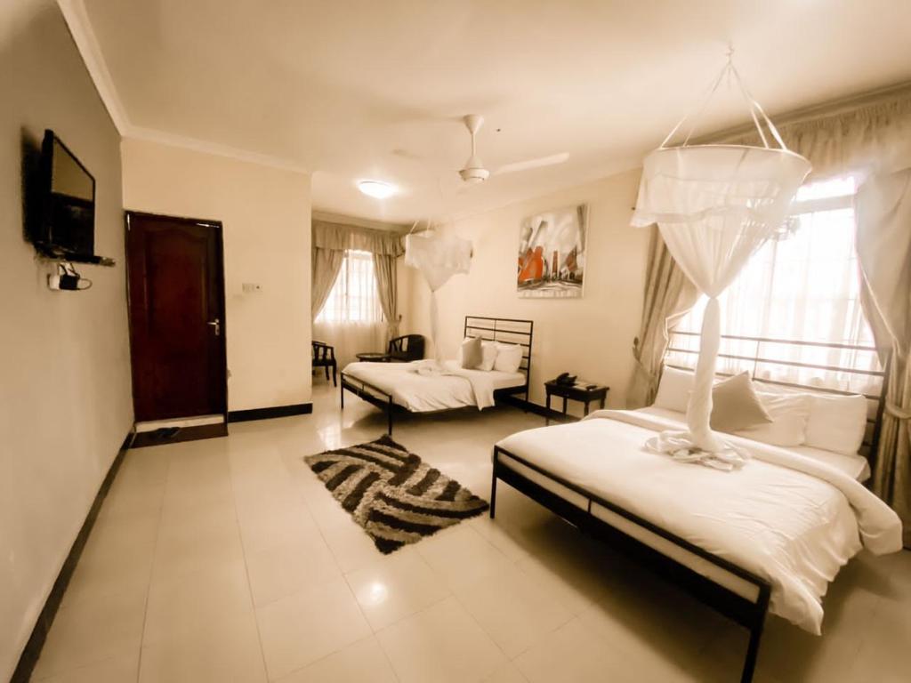 1 dormitorio con 2 camas y sala de estar en M Hotel, en Dar es Salaam