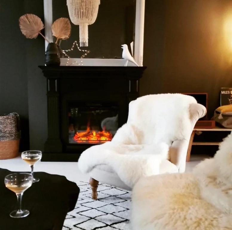 salon z białym krzesłem i kominkiem w obiekcie PENINSULAR HOUSE w mieście Camaret-sur-Mer