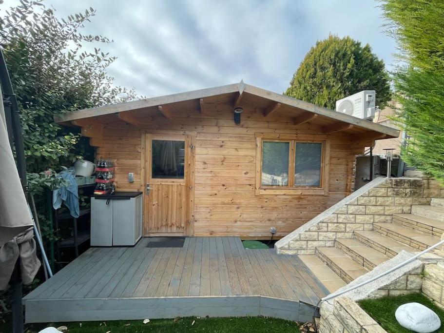 eine Holzhütte mit einer Holzterrasse im Hof in der Unterkunft Chalet de jardin in Marseille