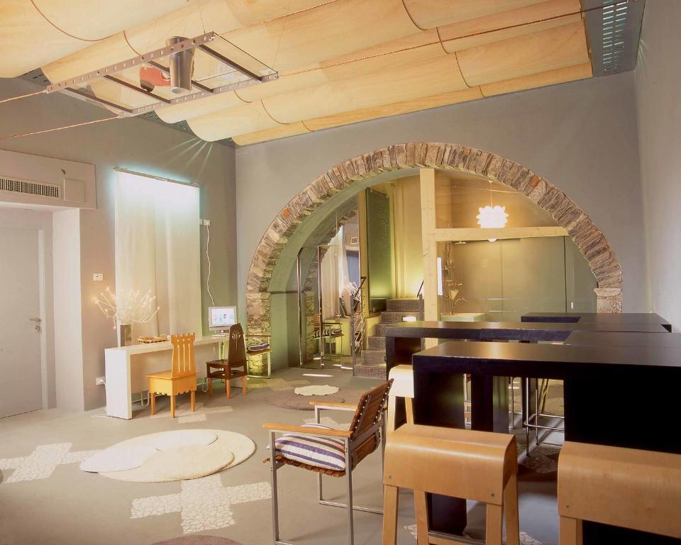 オルタ・サン・ジューリオにあるホテル アラコエリのテーブル、椅子、鏡が備わる客室です。