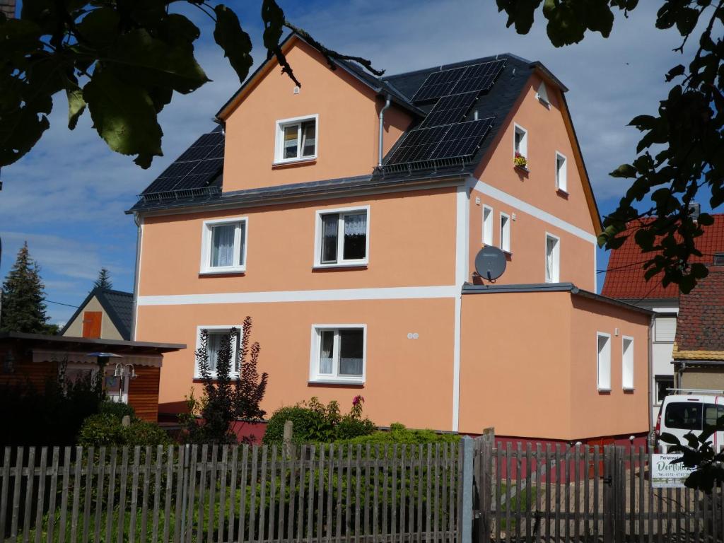 una casa con paneles solares en el techo en Ferienwohnung Dorfblick, en Kössern