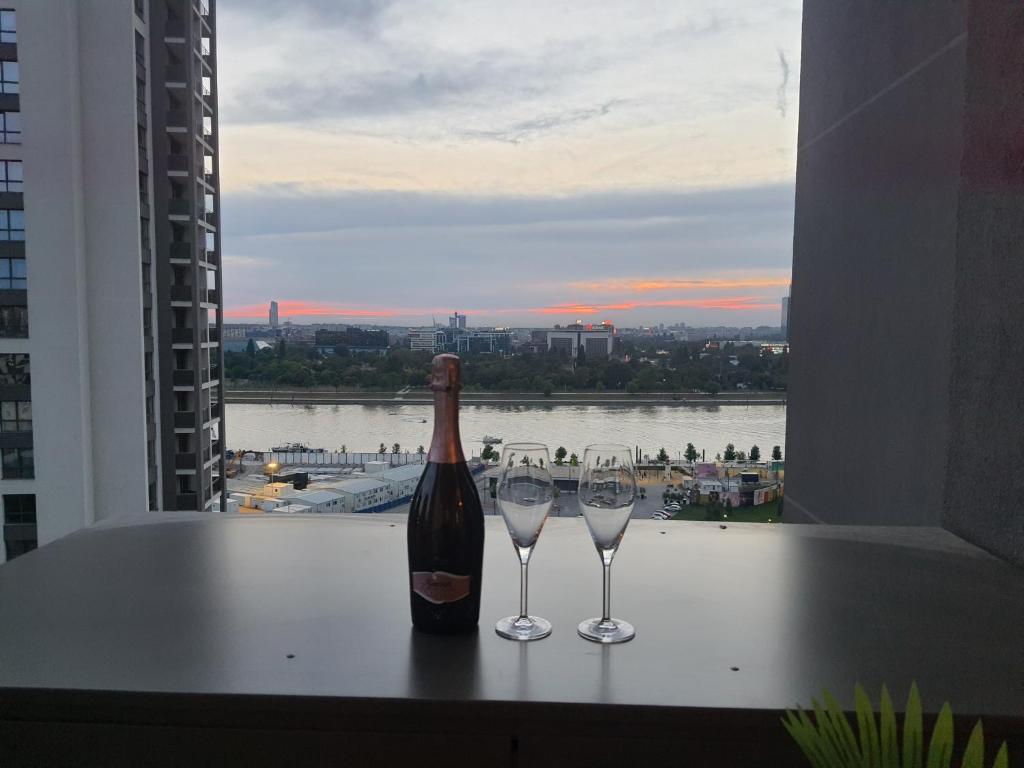 een fles wijn zittend op een tafel met twee glazen bij Belgrade Waterfront Lux Apartment in Belgrado