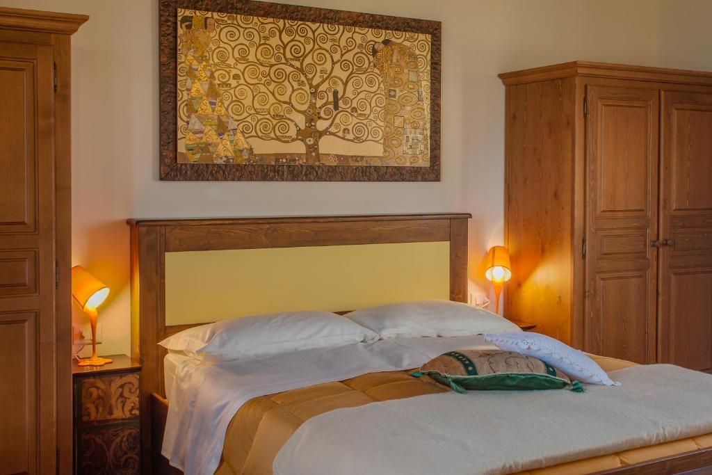 a bedroom with a bed with a tree picture on the wall at Agriturismo Primaluna in Castenaso