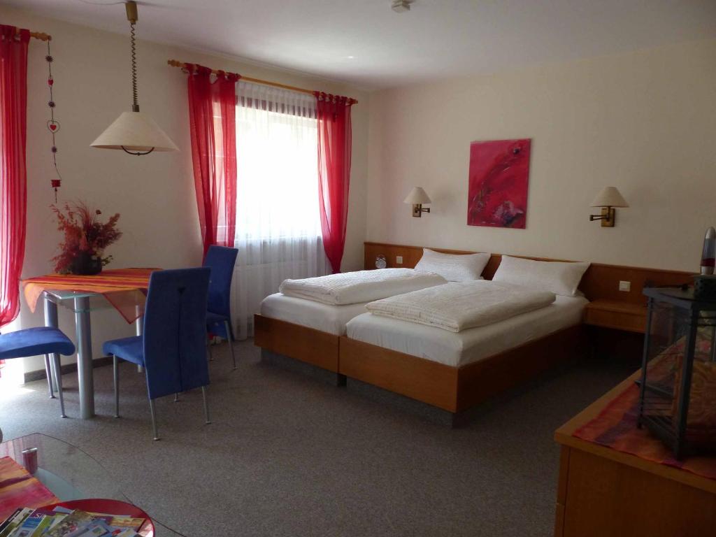 a hotel room with a bed and a table and chairs at Golf-Appartement Sonnenblick in Neualbenreuth