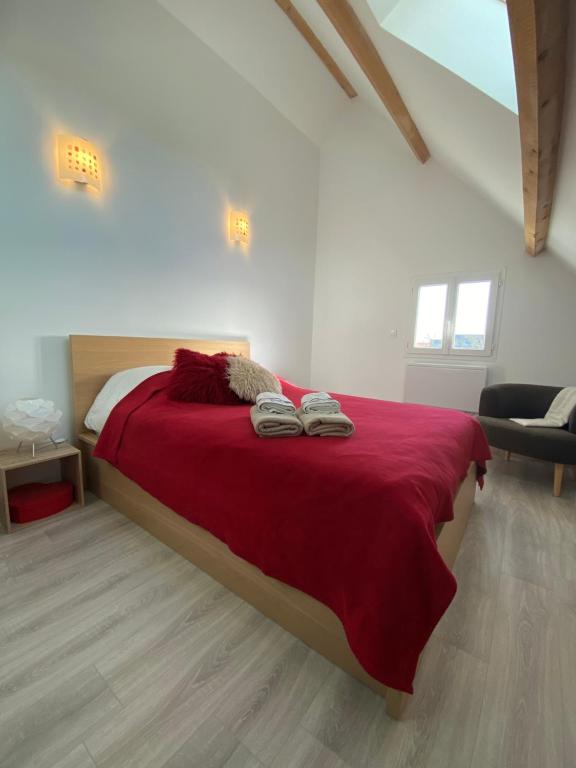 a bedroom with a red bed with two pairs of shoes on it at T2 Duplex Châtelaillon-Plage in Châtelaillon-Plage