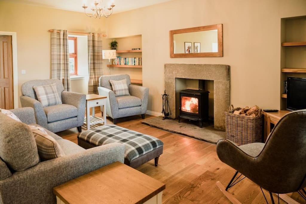 a living room with a couch and chairs and a fireplace at The Shepherd's Rest in Thurso