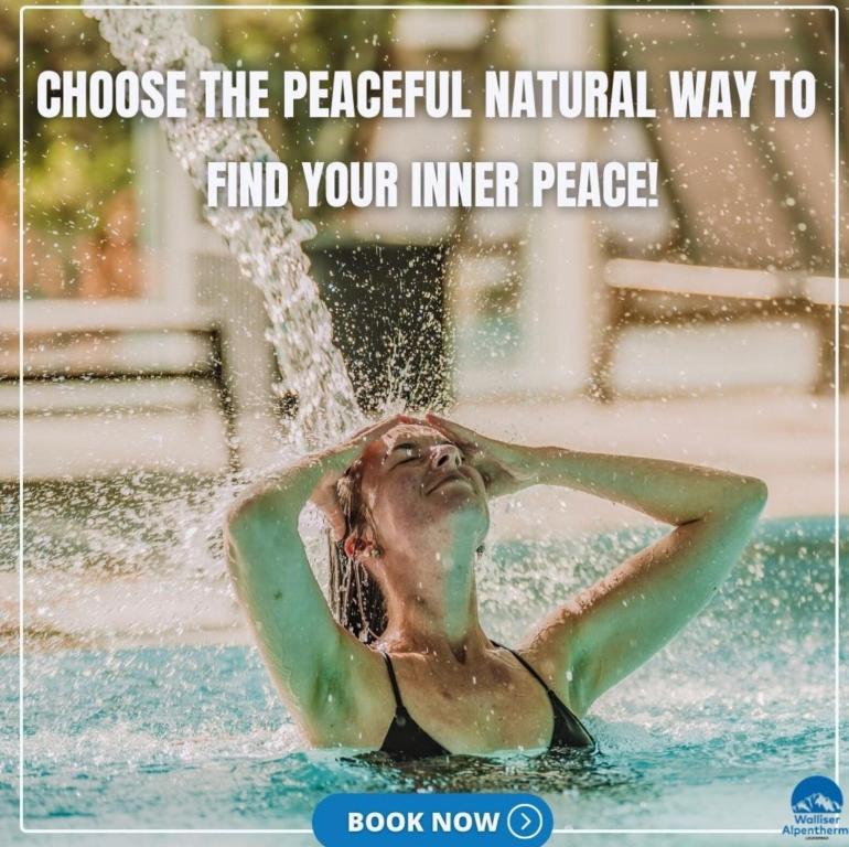 a woman in the water under a fountain at Thermal Hotels & Walliser Alpentherme Leukerbad in Leukerbad