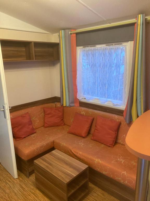 un salon avec un canapé et une fenêtre dans l'établissement Camping l’r pur, à Saint-Vincent-sur-Jard