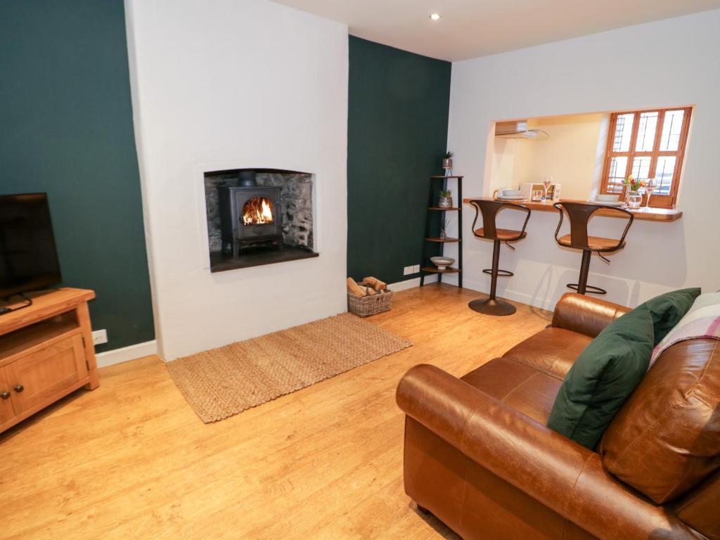 a living room with a couch and a fireplace at 14 Llewelyn Street in Conwy