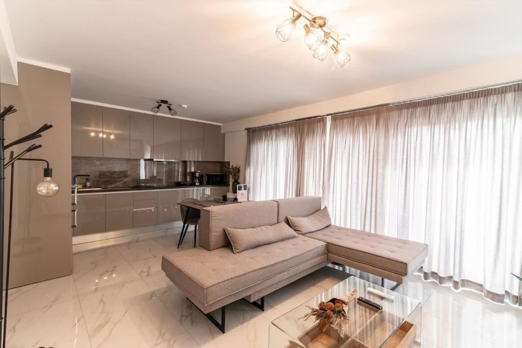 a living room with a couch and a kitchen at Μεζονέτα με θέα στο πάρκο Σταύρος Νιάρχος ONE in Athens