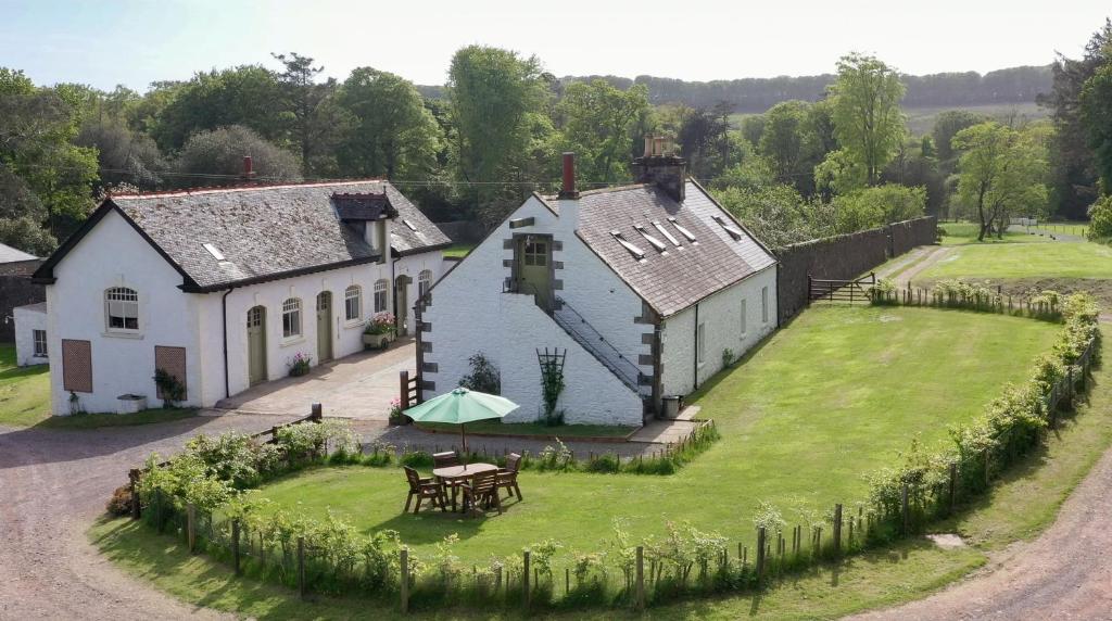 - une vue aérienne sur une maison avec une table dans la cour dans l'établissement Stables Cottage, à Stranraer