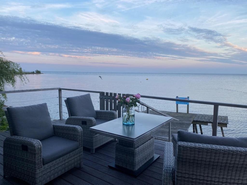 een patio met stoelen en een tafel met uitzicht op het water bij Seaside - a75754 in Bovenkarspel