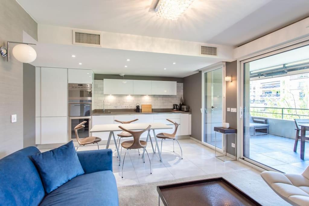 坎城的住宿－C2 Suite Pool Montfleury 2BDR Balcony, Parking & AC，一间带蓝色沙发的客厅和一间厨房