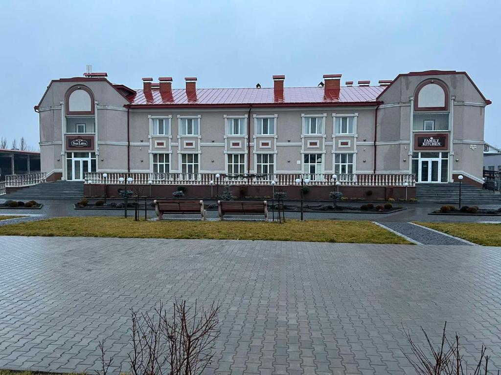 a large building with a bench in front of it at Sun Lidia in Chernivtsi