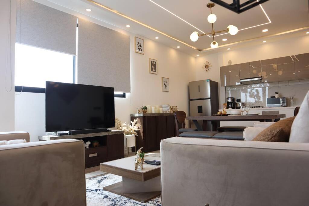 a living room with couches and a flat screen tv at Luxurious and Central Apartment 2Br in Xalapa