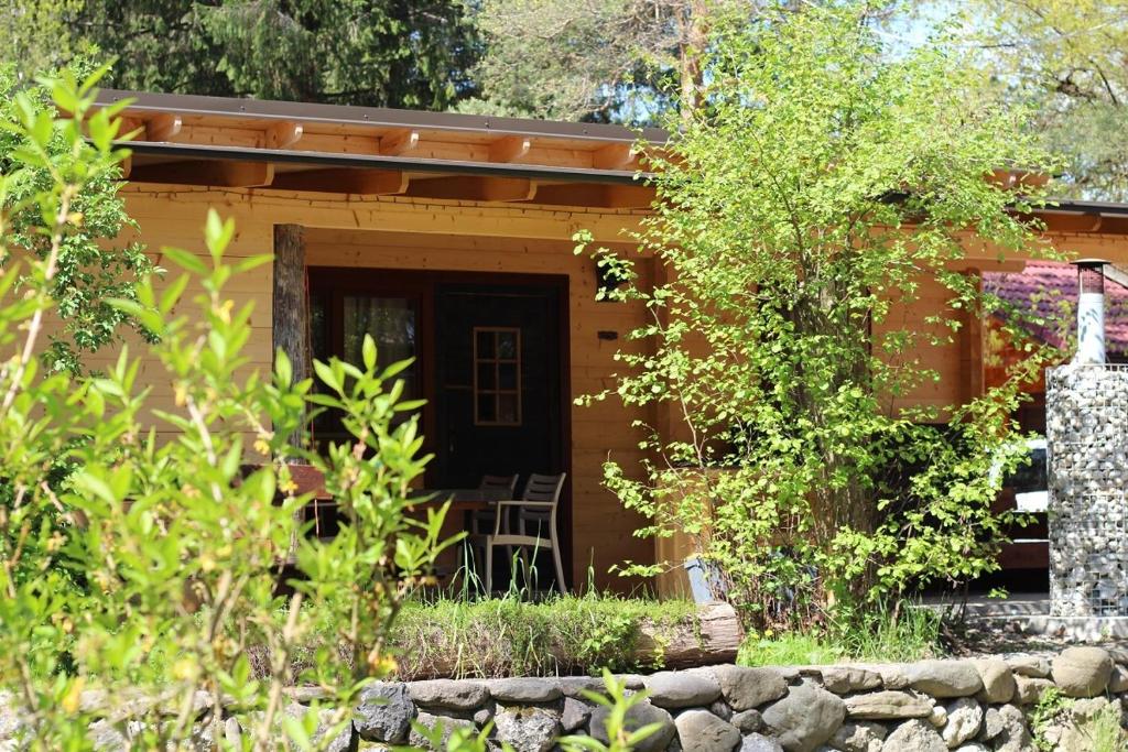 una casa con una mesa y sillas frente a ella en Wooden lodge with jacuzzi, en Rečica ob Savinji