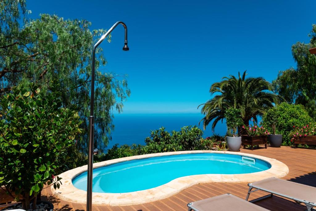 a swimming pool with the ocean in the background at One bedroom villa with sea view private pool and furnished garden at Tijarafe in Tijarafe