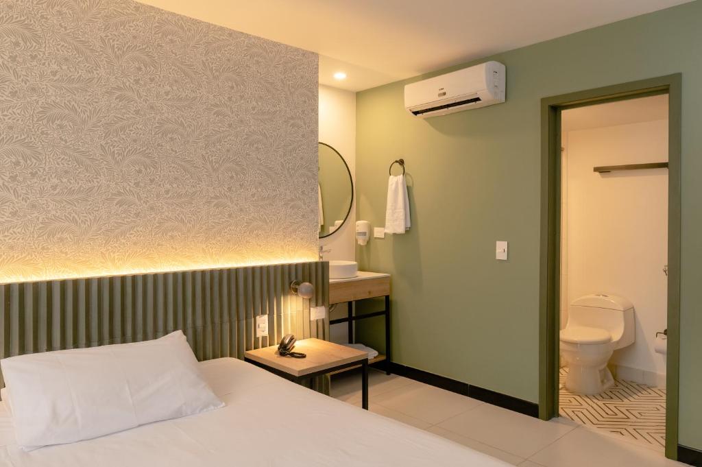um quarto com uma cama e uma casa de banho com um WC em Hotel Principe em Tuluá