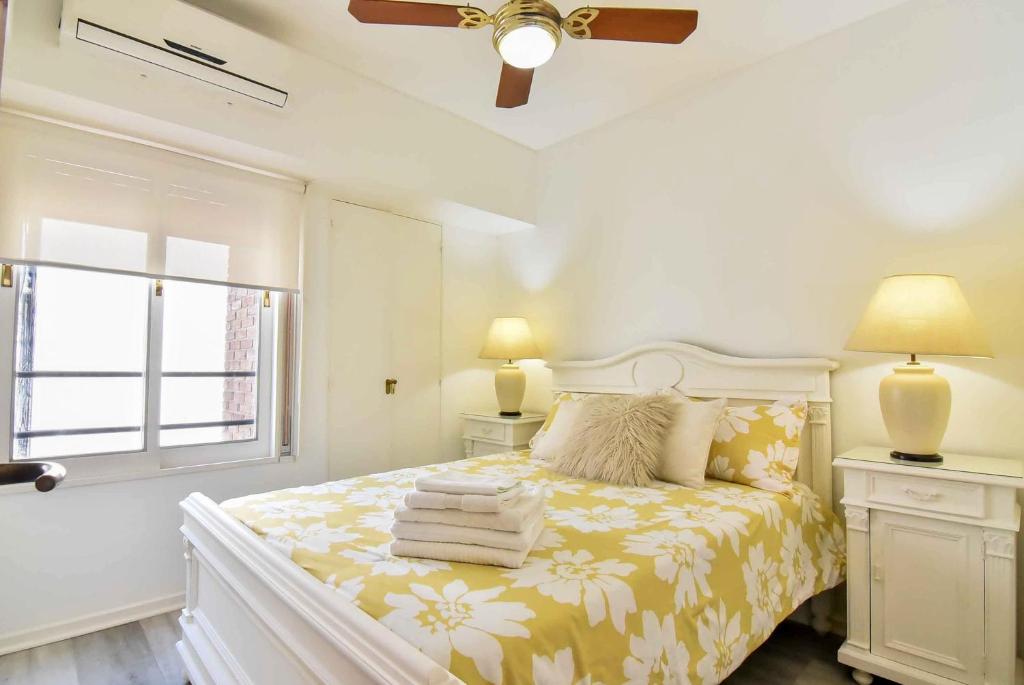 een witte slaapkamer met een bed en een raam bij Recoleta excelente ubicación in Buenos Aires