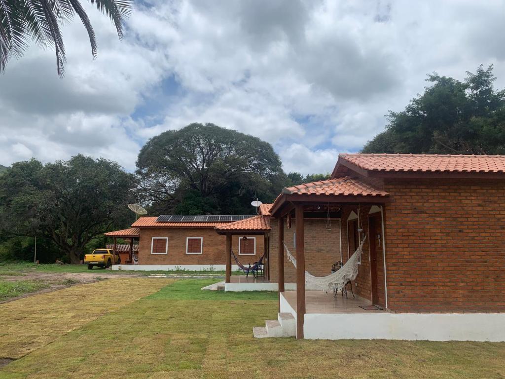 a brick house with a hammock outside of it at Chalé Topázio no Recanto Diamantina entre Palmeiras e Capão in Palmeiras