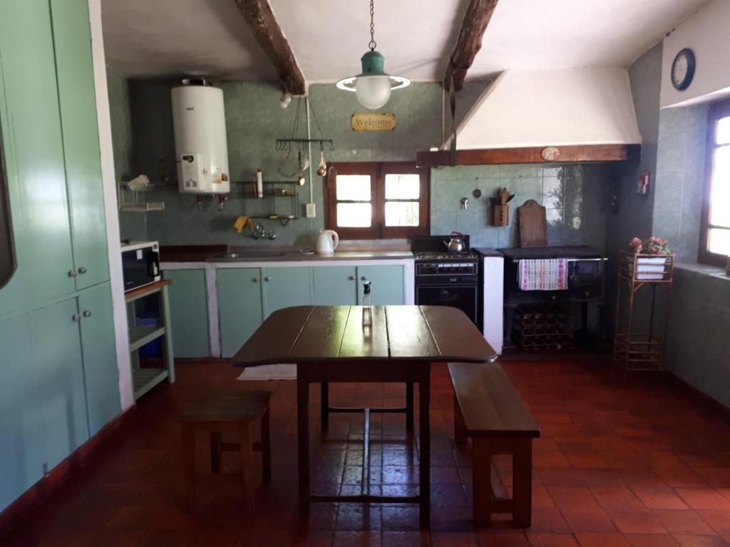 una cocina con una mesa de madera en el medio. en Casa quinta Santa Ines en Buenos Aires