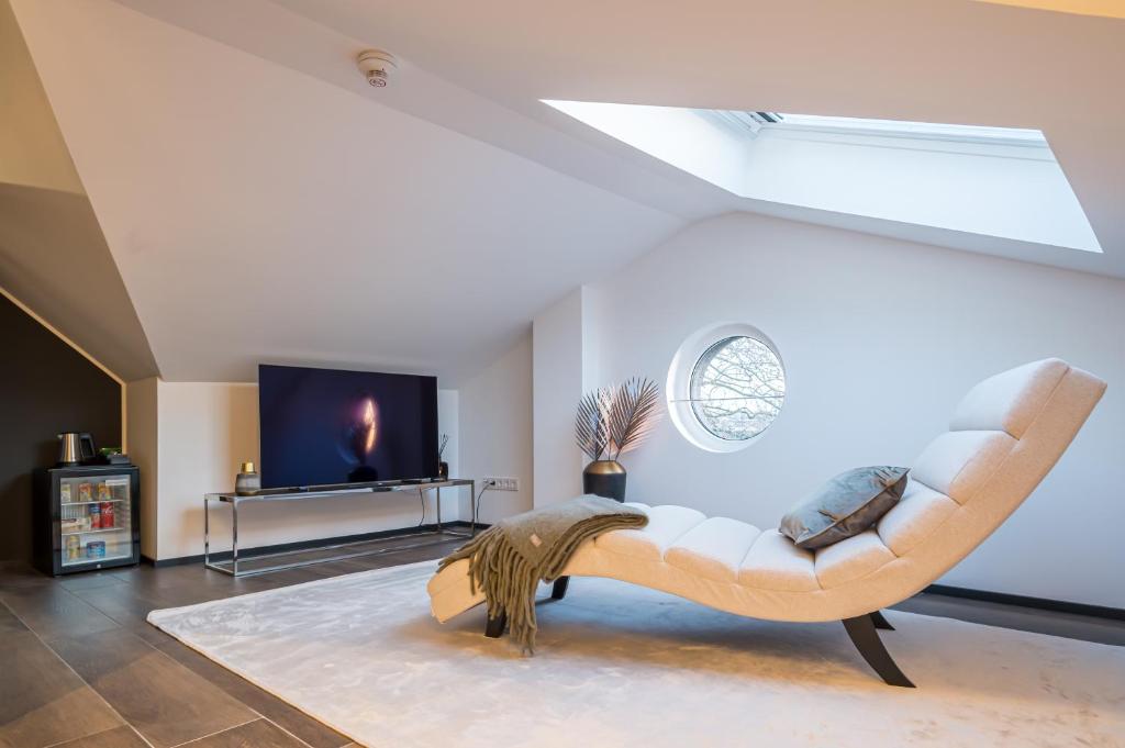 a living room with a couch and a tv at Sellmann´s Boutique Hotel in Dortmund