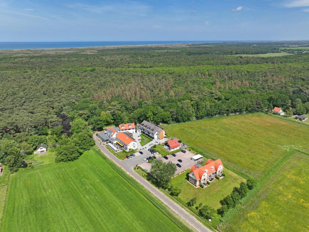 eine Luftansicht eines großen Hauses mit roten Dächern in der Unterkunft Appartementen Bos en Duin Texel in Den Hoorn