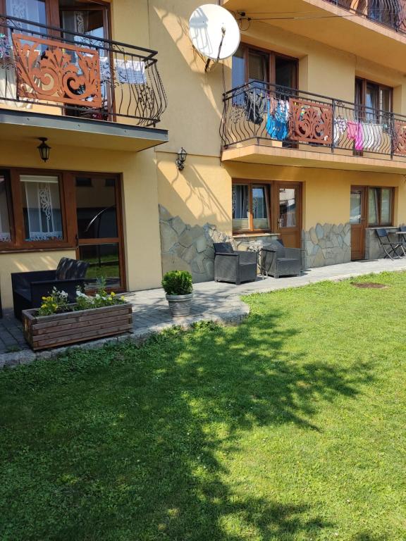 a house with two balconies and a yard at Pokoje i apartamenty u Bartka in Szczawnica