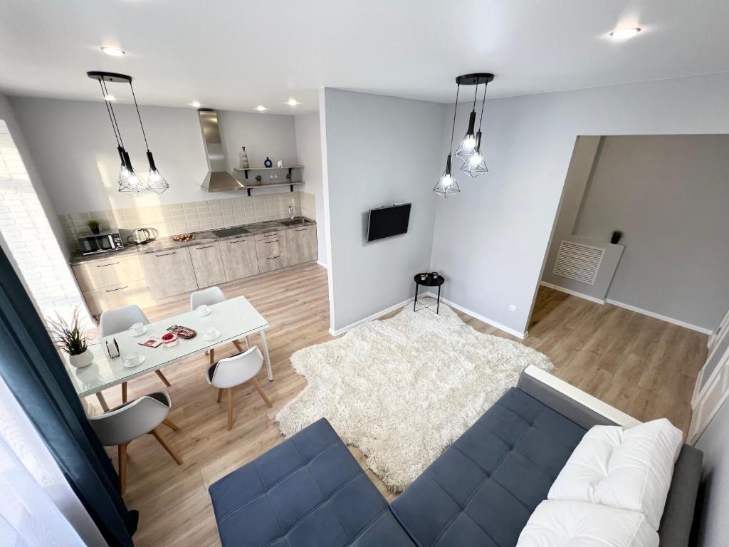 ein Wohnzimmer mit einem blauen Sofa und einem Tisch in der Unterkunft LUX в новом ЖК in Pawlodar