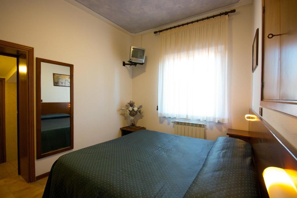 a bedroom with a blue bed and a window at Affittacamere Dal Falco in Pienza