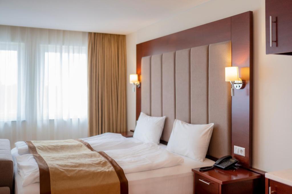 um quarto de hotel com uma cama e um telefone em Palast Hotel em Hürth