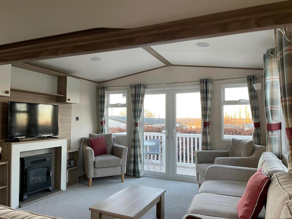a living room with a fireplace and a balcony at Rockley Park Private Holiday Homes in Poole
