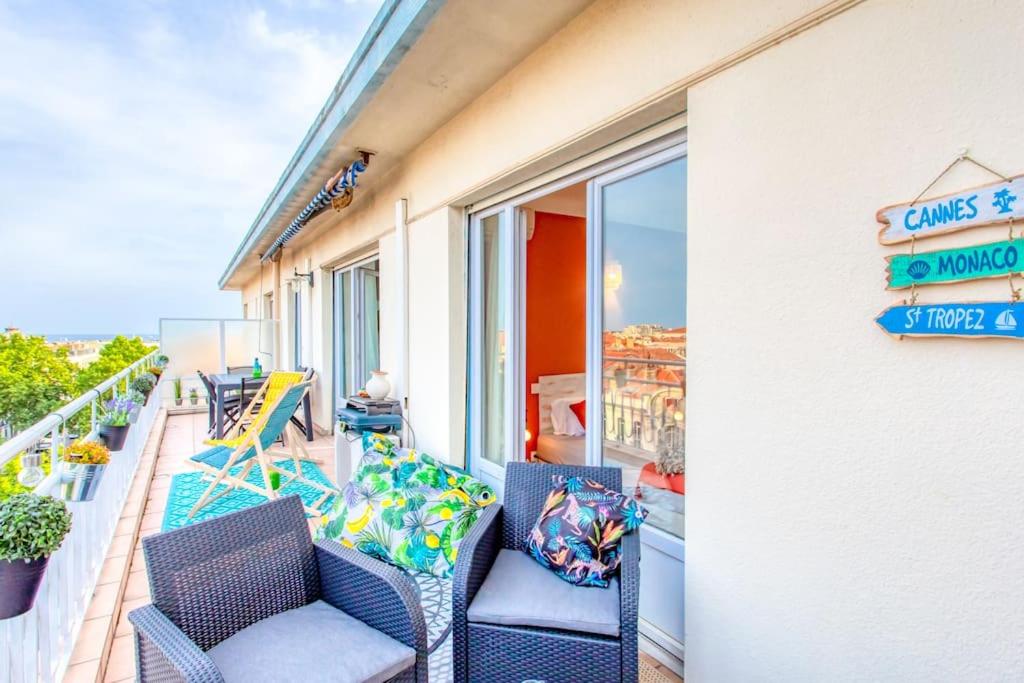 - un balcon avec des chaises et un panneau sur un bâtiment dans l'établissement C5 - 2 BDR Blvd Carnot - 10 min Palais - AC & Terrace Sea View, à Cannes
