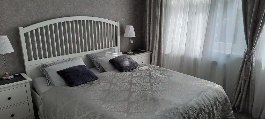a bedroom with a white bed with pillows and a window at Villa Shafaly in Mariánské Lázně