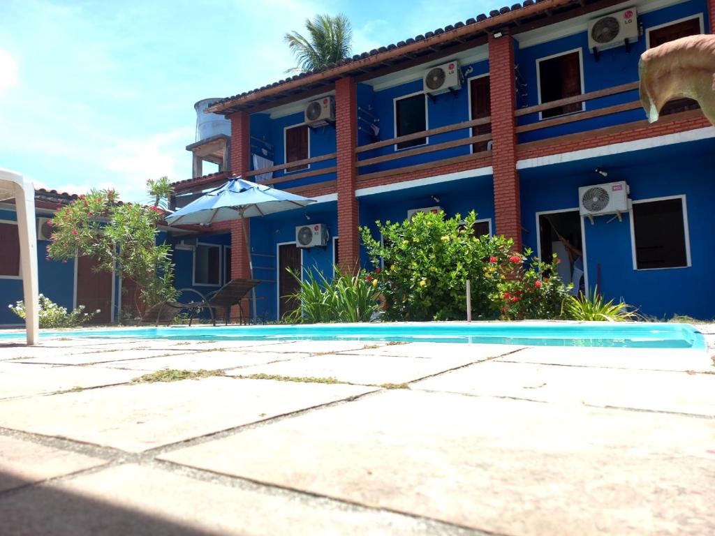 uma casa com uma piscina em frente em Pousada Flor do Dendê em Arraial d'Ajuda