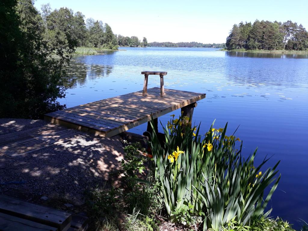 a small wooden dock in the middle of a lake at Unterkunft am See in Skånes Fagerhult