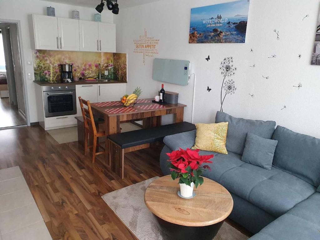 a living room with a blue couch and a table at Ferienwohnung Winklworld inklusive aktivCARD in Sankt Englmar