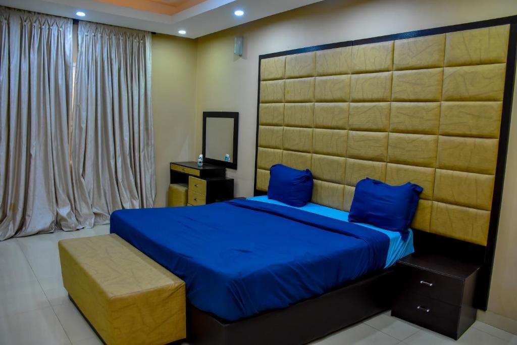 sypialnia z łóżkiem z niebieską pościelą i niebieskimi poduszkami w obiekcie Beautiful Town House w mieście Lagos