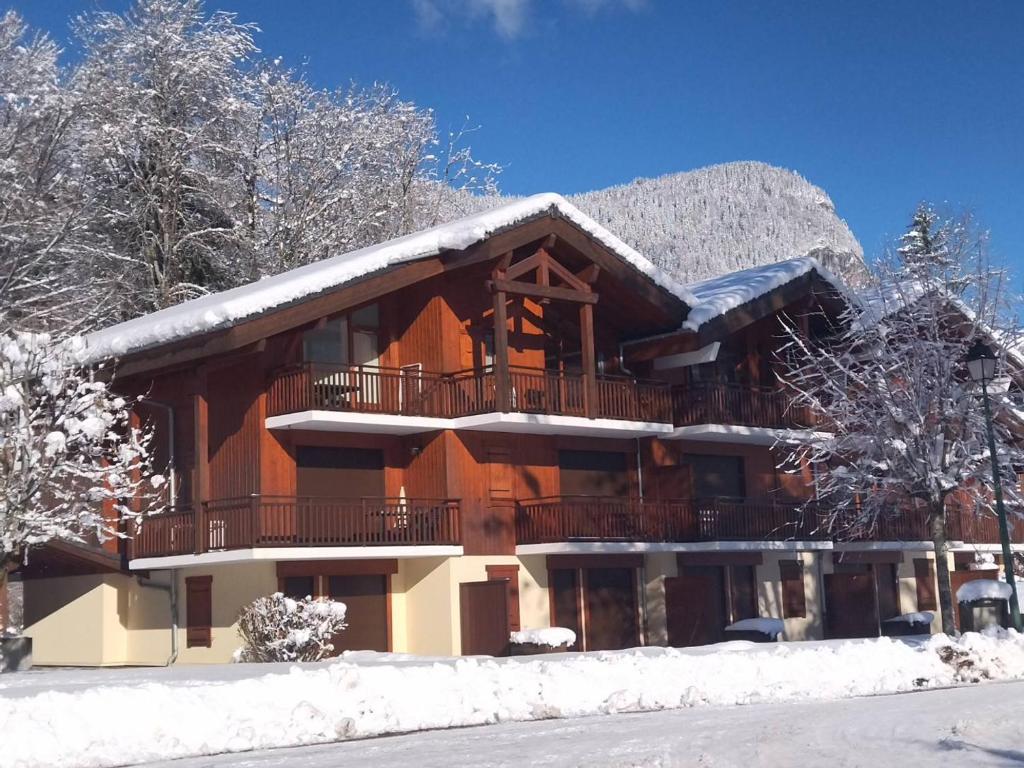 ein großes Gebäude mit Schnee auf dem Dach in der Unterkunft Multi résidences Samoëns in Samoëns